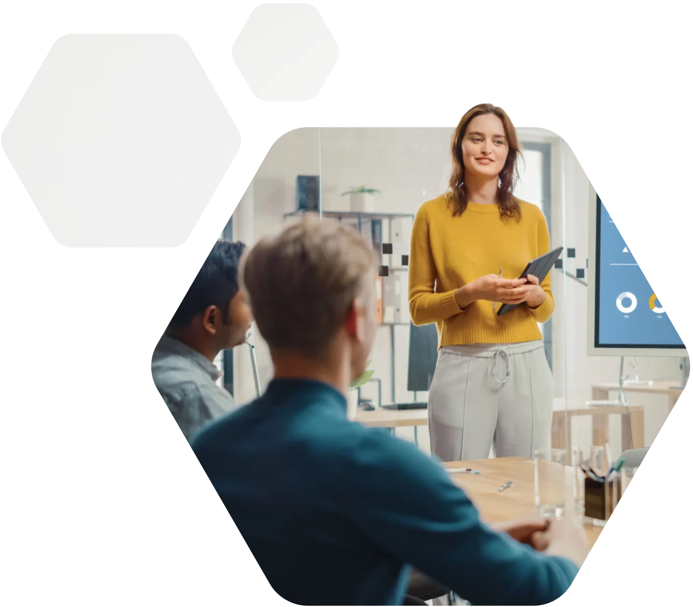 A woman holding a tablet and making a presentation in front of two of her colleagues.