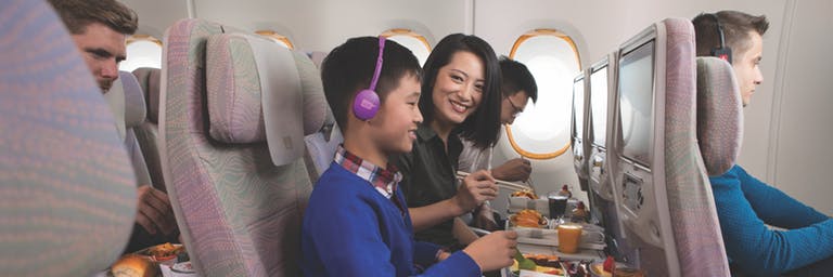 Une famille déguste son repas en Classe Économique de l’Airbus A380 d’Emirates