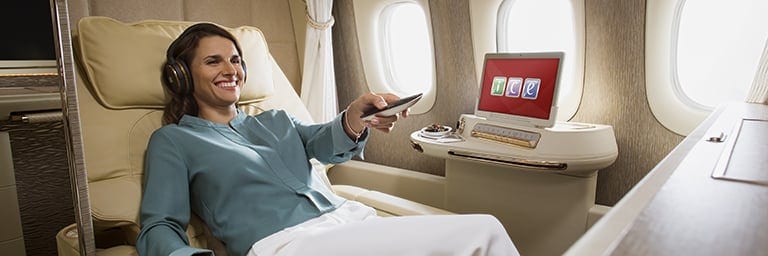 smiling passenger enjoying the inflight entertainment in Emirates B777 First Class