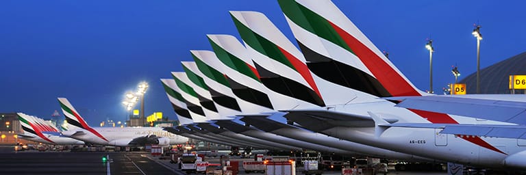 Aletas traseras de Emirates en la terminal 3 del aeropuerto internacional de Dubái por la noche