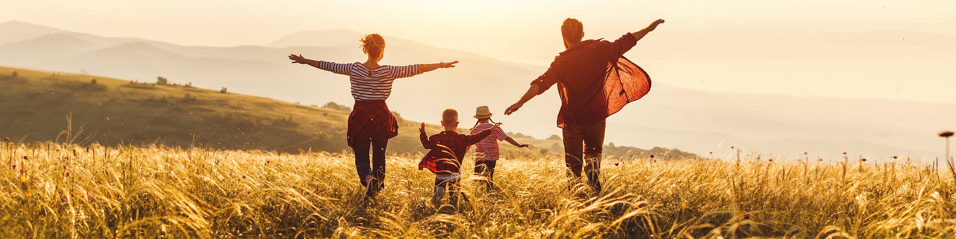 Happy family walking together outdoor in the nature on sunset