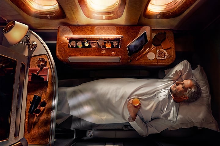 Une femme dort sur son siège-lit en Première Classe à bord de l'A380 Emirates