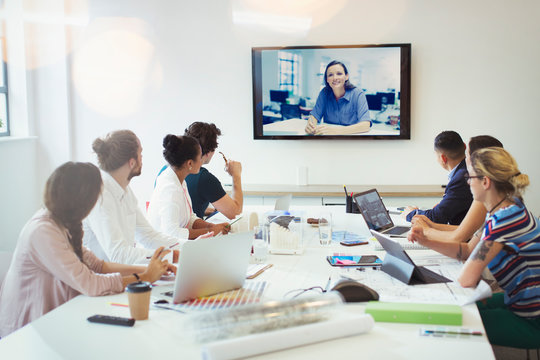 Designers video conferencing in conference room meeting