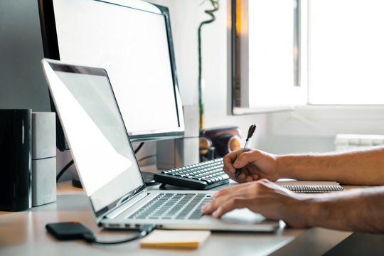 Person working from home at their desk with computers