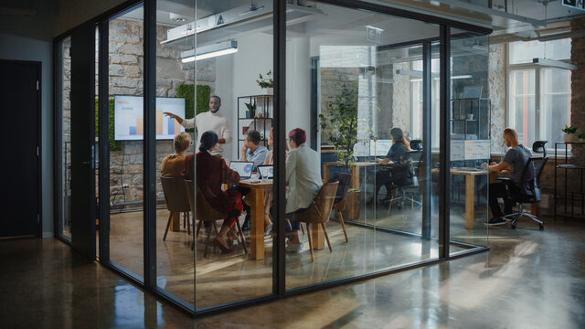 Office Conference Room Meeting: Male Chief Executive Talking to a Diverse Team of Professional Businesspeople. Creative People Listen to CEO Discuss Design, Data Analysis, Plan Marketing Strategy