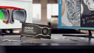 An AMD Radeon GPU on a desk in front of a pair of computer monitors