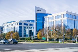 A white brick office site with blue windows with the word Citrix displayed on the tallest building