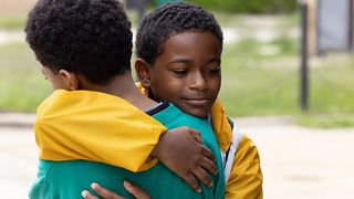 Two boys hug in 