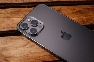 iPhone 12 Pro Max phone on a table with the three camera lenses facing up