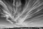 Black and White photograph of {quote}Mare's Tail{quote} clouds streaming over Nome in Alaska.
