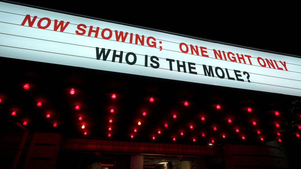 A marquee reads “NOW SHOWING; ONE NIGHT ONLY WHO IS THE MOLE?”