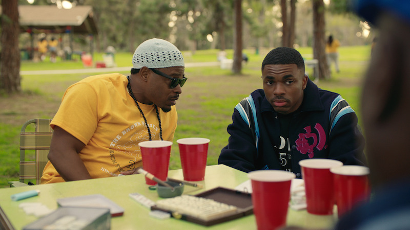 Kareem Grimes as Uncle Mike and Vince Staples as Vince Staples sit at a table with red cups in season 1 of 'The Vince Staples Show'