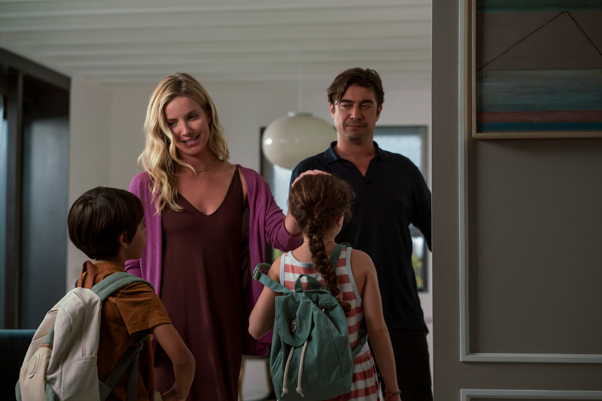 Lorenzo Ferrante as Giovanni, Annabelle Wallis as Elena, Gaia Coletti as Bianca, and Riccardo Scamarcio as Pietro stand together at an apartment door in the film ‘Vanished into the Night.’