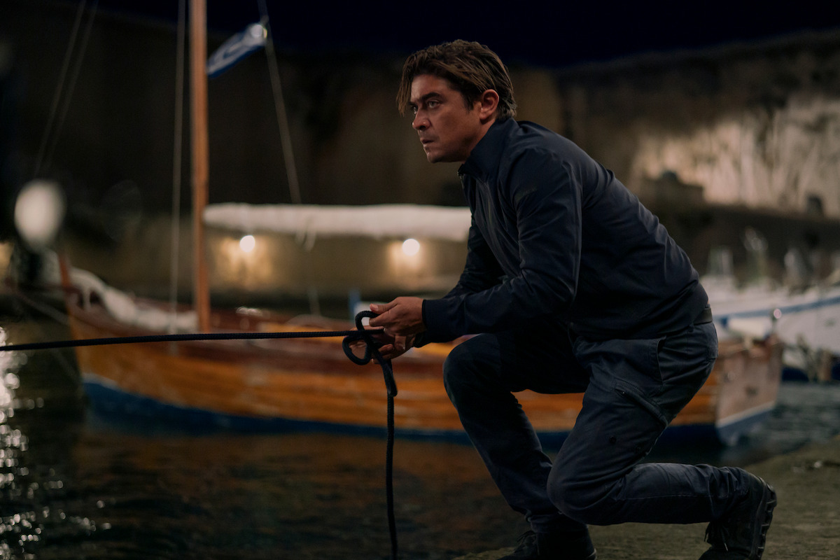 Riccardo Scamarcio as Pietro holds a rope on a beach at night in the film ‘Vanished into the Night.’