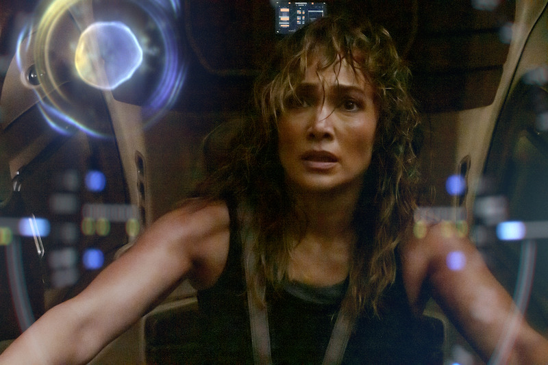 Jennifer Lopez as Atlas sitting in a chair looking distressed.