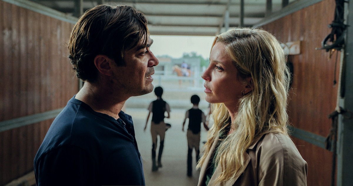 Riccardo Scamarcio as Pietro La Torre and Annabelle Wallis as Elena Walgren stand and face each other with concerned expressions in 'Vanished into the Night'