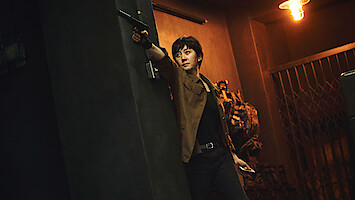 Yum Jung-ah as Kang Mi-seon points a gun down a hallway in an image from the film 'Mission: Cross.'