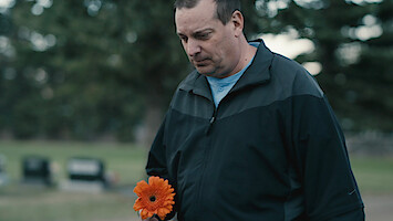  Amanda's brother Darrell Hogg holds a flower that he will place on her grave.