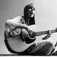 Black and white photo of Joni Mitchell playing the guitar