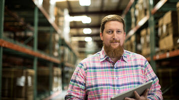 An employee in a warehouse holding a tablet