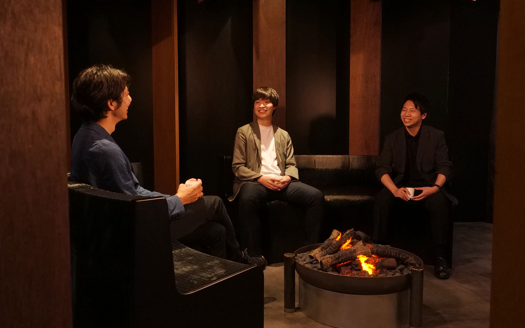 Photo: three people talking by the fire