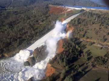 Oroville Dam on 2/11/2017. The main spillway (center) is heavily damaged, so water is being let through the emergency spillway (top). There are concerns that the emergency spillway may erodeCredit: William Croyle, California Department of Water Resources The large gully to the right of the main spillway was caused by water flowing through its damaged concrete surface.