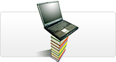 A laptop perched on a tall stack of books