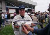 Angler Holding Fish with Sea Lamprey Wounds