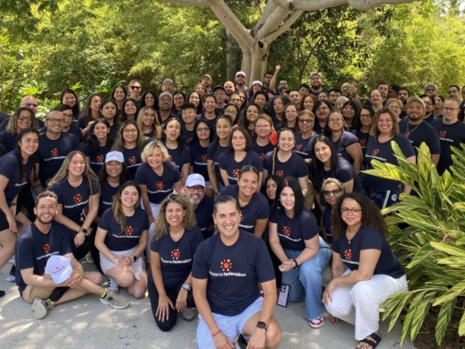 a large group of individuals who work for the same organization smiling for a group photo