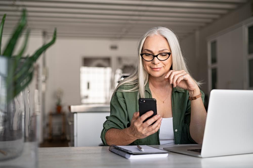 A person looking at their phone in a kitchen