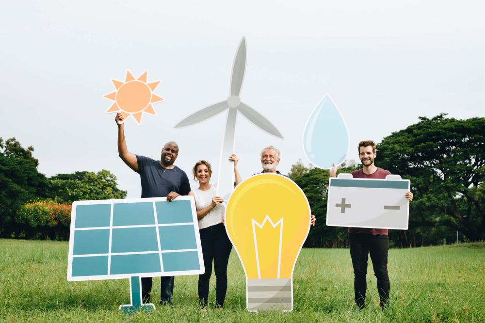 Community members holding renewable energy signs on an open field