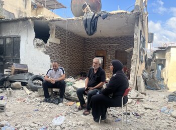 A displaced Palestinian family sitting amid the rubble of their destroyed home in Tulkarm refugee camp, following an Israeli operation. Photo by OCHA, 7 September 2024 