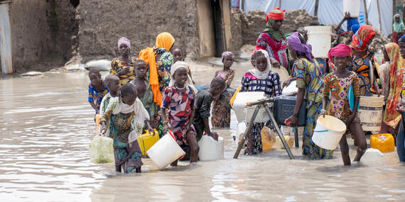 Children walking in flood areas with buckets