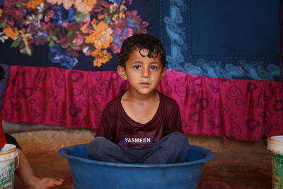 A child sits in a tub of water to beat the heat in Al-Hamra camp for internally displaced people in Syria’s Idleb governorate. 