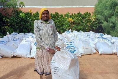 Issaq, a resident of the Bambusul IDP camp in Baidoa, affected by the El Niño floods in 2023, receives an emergency standard NFI kit and plastic sheets