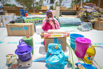 A woman displays her aid card after receiving relief supplies from humanitarian partners. Mali, floods