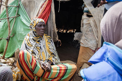 Fatuma Alinoor, 58, sits outside her shelter in Somalia's Biliil IDP camp, where she lives with her three grandchildren after fleeing drought and food insecurity in Dinsoor.