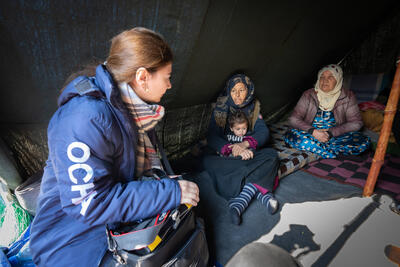 A worker assists individuals in a temporary shelter.