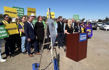 Cindy Chavez speaking at podium with supporters behind her