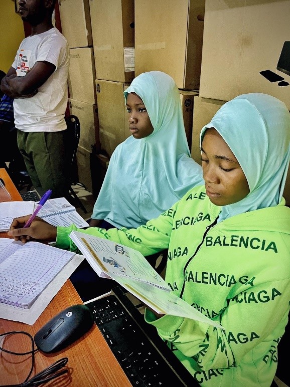 A photo of 2 female students scanning through the RWC Student quick guide at the Gvernment High School Adeta, Ilorin during the training session