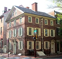 Red brick house with many windows at the corner of a block