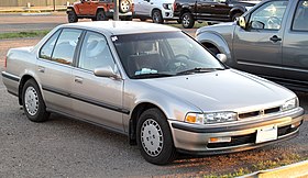 Front three-quarter view of a front-engined four-door five-passenger car with a three-box body style incorporating a luggage compartment separate from the cockpit.