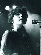 Black-and-white photo of Björk looking upwards while standing in front of a microphone