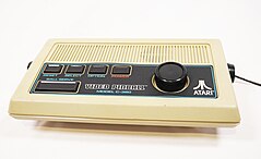 Atari Video Pinball games console model C-380 cream colored. Image shows a white plastic case with five buttons and a dial. The buttons are labelled reset, select, option, power and "ball serve".