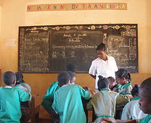 Students working in groups in classroom as teacher observes