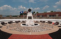 Circular plaza with sculpture of a cross in the center and plaques on the outside