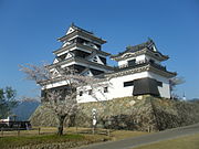 在从八幡滨站乘坐电车的场景中，从日出川沿岸的道路上可以看到大洲城。