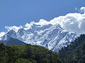 Snow covered Gyala Peri peak in the background seen through 2 other peaks in the foreground, c. October 2011.