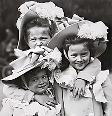 Photo of the three girls wearing identical decorated broad-brimmed hats.