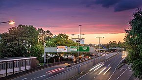 View of both carriageways of the ring road and junction 9 slip roads, with overhead signage, taken at dusk